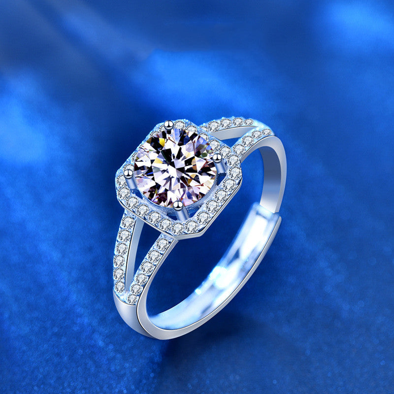 Silver ring with a large diamond and smaller diamonds on a blue background